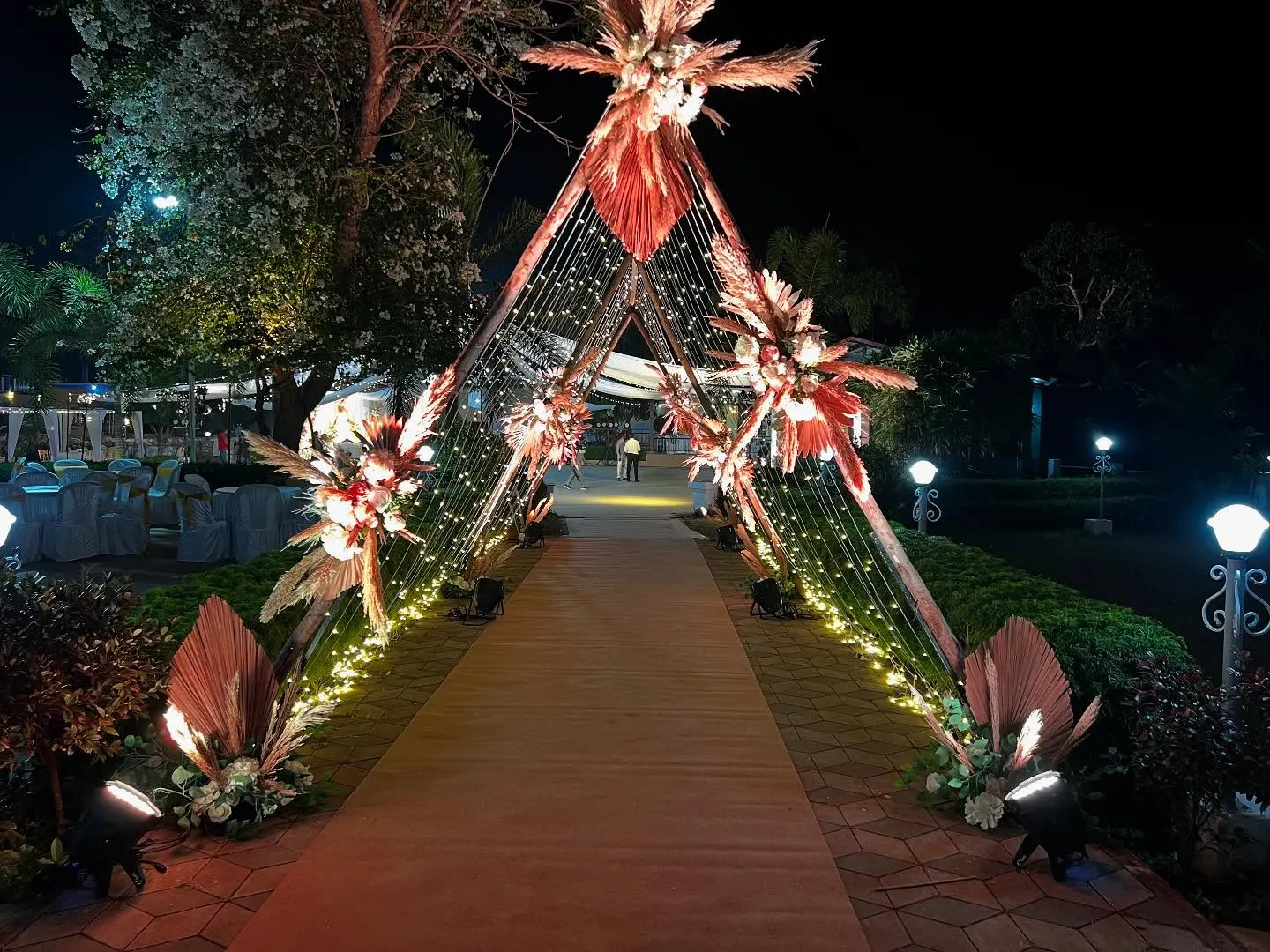 Teepee-style entrance with pampas grass and fairy-light curtains