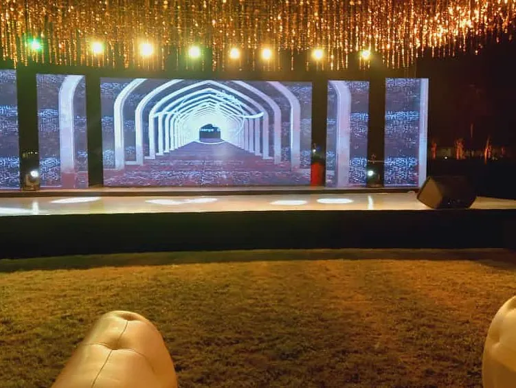 Sangeet stage with LED screen and cascading golden chandelier lights by Imagine Decorators